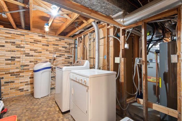 masina za pranje i sušilica u nedovršenom podrumu sa vidljivim instalacijam