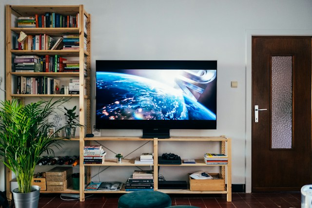 Zidni televizor prikazuje planetu među policom i vratima